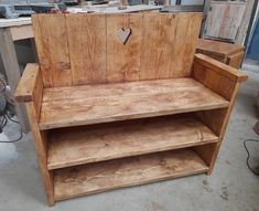 a wooden bench with a heart cut out on the back and shelf below it in a shop