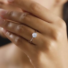 a woman's hand with a diamond ring on it