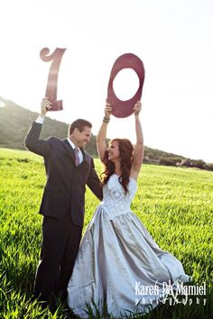 a bride and groom holding up the number one