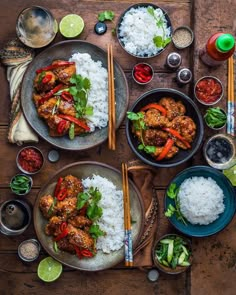 an overhead view of two plates of food with rice and chopsticks on the side