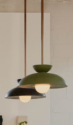 three lights hanging from a ceiling in a room with white walls and wooden flooring