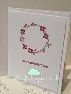 a white card with a red flower on it and the words on your perfect day