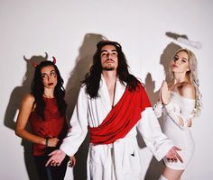 three people dressed in costumes standing next to each other with horns on their head and one woman wearing a devil costume