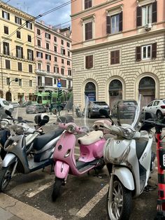 several scooters are parked on the side of the road in front of buildings