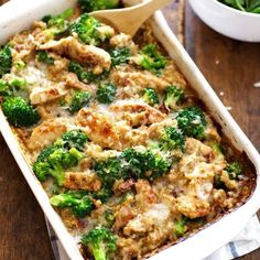 a casserole dish with broccoli and meat in it on a wooden table