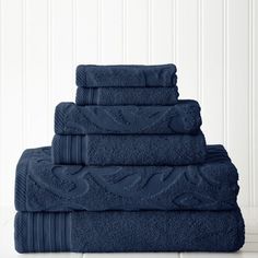 five towels stacked on top of each other in blue color, one folded and the other folded