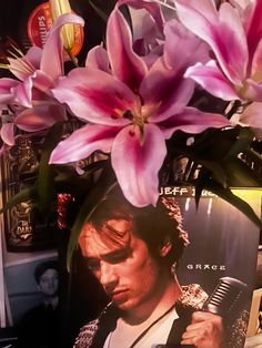 a vase filled with pink flowers sitting on top of a table next to a magazine