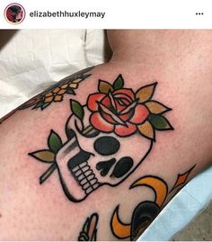 a woman's thigh with a skull and rose tattoo on it