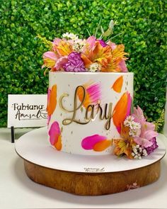 there is a cake with flowers on it and a sign in the background that says lady