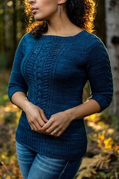 a woman standing in the woods with her hands on her hips and looking off to the side