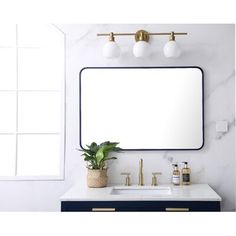 a bathroom vanity with a large mirror above it and two lights on the wall next to it