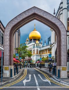 an archway leading to a building with a gold dome on it's top and bottom