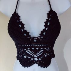 a crocheted halter top is displayed on a mannequin