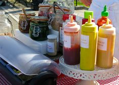 an assortment of condiments on a table outdoors