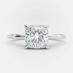 a cushion cut diamond engagement ring on a white background