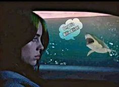 a woman in the back seat of a car looking at a shark with a thought bubble above her head