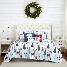 a bed with christmas decorations on it and a wreath hanging above the headboard, in front of a white brick wall