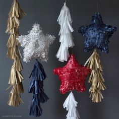 five different colored stars hanging from strings in the shape of snowflakes and pine cones