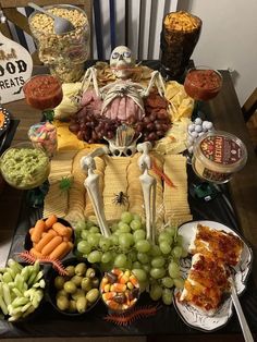 a table topped with lots of food and halloween decorations on top of eachother