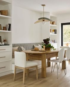 a dining room table with white chairs around it