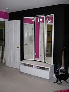 a room with black walls and white furniture in the center, pink accents on the wall