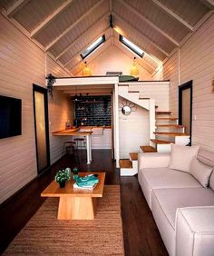 a living room filled with furniture and a flat screen tv on top of a wooden table