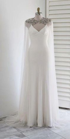 a white wedding dress on display in front of a window