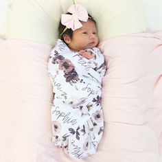 a baby wrapped in a blanket laying on top of a pink pillow with the words happy new born