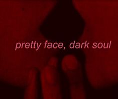 a hand holding a red object with the words pretty face, dark soul on it