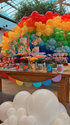 a rainbow themed birthday party with balloons and cake