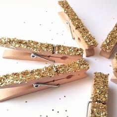 gold glittered wooden clothes pins on white background