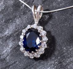 Diamond Pendant set with a Created Sapphire in a Diamond cut, flawless clarity & royal blue color, surrounded with small CZ Diamonds (8 Cts all).Solid 925 Sterling Silver ☞ made to last. Click here for ☞ Matching RingClick here for ☞ Matching Earrings Details:♥ Created Sapphire & CZ Diamonds in a flawless clarity♥ Sapphire: 14x10mm, 6 Ct, diamond cut♥ CZ Diamonds: 3mm each, 1.5 Ct combined, diamond cut♥ Dimensions: Pendant Height 30mm, Width 16mm♥ Free Complementary Chain♥ Solid 925 Sterling Sil Diana Necklace, Sapphire Diamond Necklace, Diamond Pendant Set, Flawless Diamond, Diamond Pendant Sets, Vintage Sapphire, Matching Ring, Blue Pendant, Sapphire Pendant