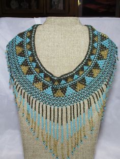 Wore this with a flowing poet shirt and denim jacket....received many a compliment...all seed beads in turquoise, dark brown and gold...inside entry is 16" and outside length is 20" x 5 1/2"...in great shape. Handwoven Blue Beaded Necklaces, Unique Handwoven Blue Beaded Necklaces, Blue Handwoven Beaded Necklace, Unique Handwoven Blue Beaded Necklace, Unique Blue Handwoven Beaded Necklaces, Bohemian Blue Beaded Necklaces With Gold Beads, Bohemian Blue Beaded Necklace With Gold Beads, Handwoven Blue Beaded Necklaces For Festivals, Handwoven Blue Beaded Necklace For Festival