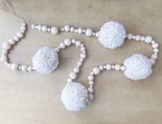 white beaded necklaces are arranged on a table