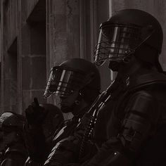 three people wearing helmets sitting on a motorcycle