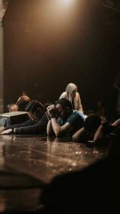 several people sitting on the floor with their arms around each other