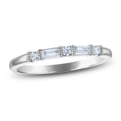 a white gold ring with three baguettes on the side and diamonds in the middle