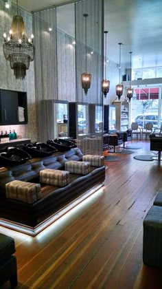 a living room filled with lots of furniture next to a wooden floor and chandelier