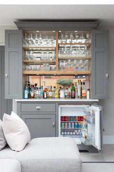 a kitchen with grey cabinets and shelves filled with bottles