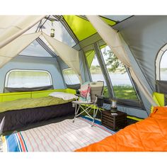 a bed sitting inside of a tent next to a window