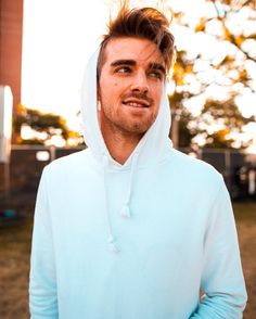 a man in a blue hoodie is standing outside