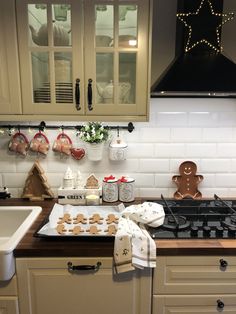 a kitchen with gingerbread cookies on the stove and other items hanging from the cabinets