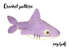 a purple stuffed shark with the words crochet pattern on it's side