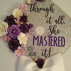 a graduation cap decorated with flowers and the words through it all she mastered