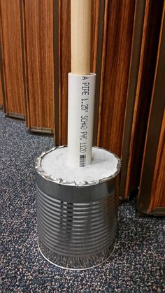 an old tin can with a baseball bat sticking out of it sitting on the floor