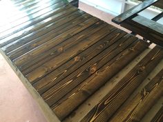 two wooden benches sitting next to each other on top of a cement floor in front of a window