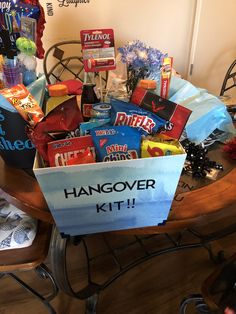 a gift basket filled with snacks and candy sits on a chair in front of a table