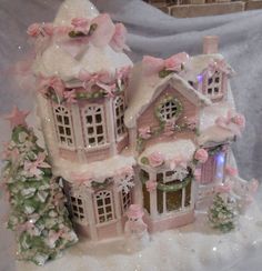 a pink and white christmas house with lights