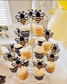 cupcakes are arranged in the shape of a bee on top of a cake stand