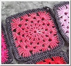 three crocheted squares with pink and red flowers on them are laying on a gray surface